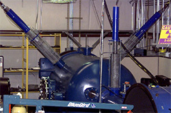 Measuring with X-Rays: The three long blue and grey colored tubes sticking out of the blue chamber in the image are flash x-ray heads. These emit x-rays briefly during a test so that specialized images of the projectile in flight and/or the projectile impacting the target can be produced.